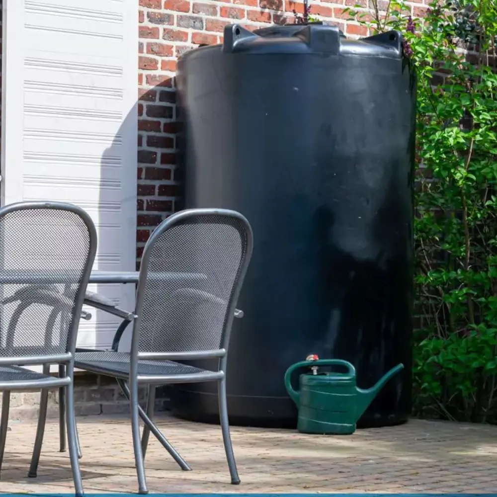 Citerne eau de pluie extérieure installée sur terrasse avec arrosoir pour jardin